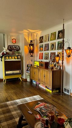 a living room filled with lots of furniture and pictures on the wall next to a coffee table