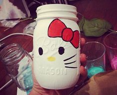 a person holding a hello kitty mason jar