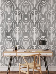 a desk and chair in front of a wall with an art deco pattern on it