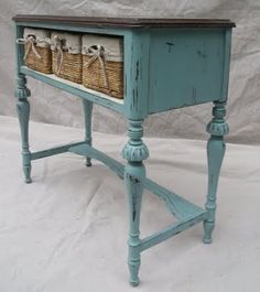 an old blue table with baskets on it