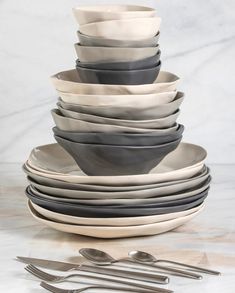 a stack of plates and silverware on a table