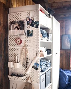 an organized closet is shown with pictures and other items on the wall, along with bookshelves