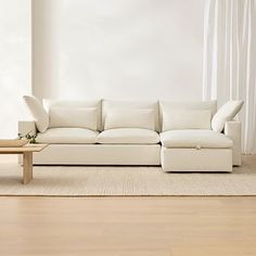 a white couch sitting on top of a hard wood floor next to a wooden table