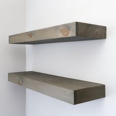 two wooden shelves are hanging on the wall