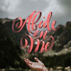 a hand reaching out to the sky with mountains in the background and text made on one side