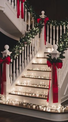 stairs decorated with christmas lights and garlands for the holiday season, as well as red bows