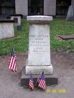 two american flags are placed in front of a monument