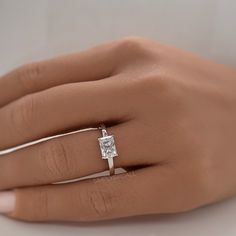 a woman's hand with a diamond ring on it