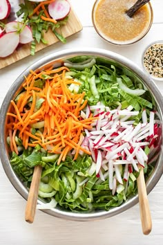 a salad with carrots, radishes and lettuce in a bowl