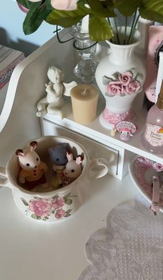 a shelf filled with dishes and cups on top of a white counter next to a wall