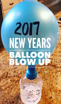 a blue balloon sitting on top of a table next to a bottle of water with the words new years balloon blow up