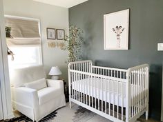 a baby's room with a white crib, chair and pictures on the wall