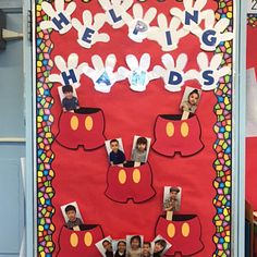 a bulletin board with pictures of children's heads on it and the words helping hands