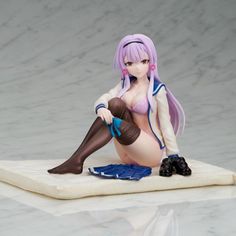 a figurine is sitting on top of a mat with her legs spread out