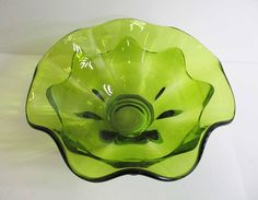 a green glass bowl sitting on top of a table