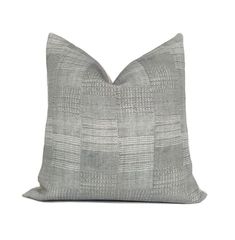 a gray and white pillow on a white background