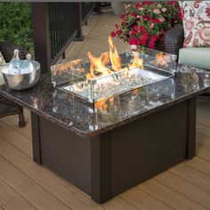 a fire pit sitting on top of a wooden floor next to two chairs and a table