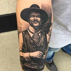 a man with a cowboy hat and vest on his arm is wearing a black and white photo