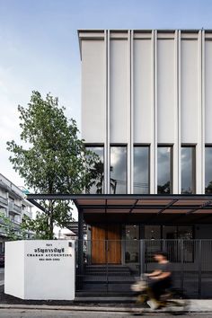 a person riding a bike in front of a building with a sign on the side