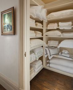 the closet is full of white linens and folded towels