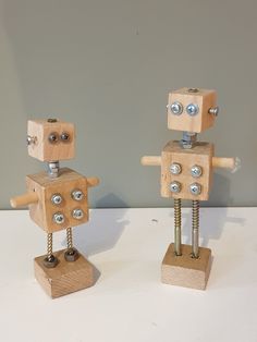 two wooden toy robots standing next to each other