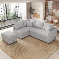 a living room with a large sectional couch and ottoman in it's center area