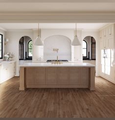 a large kitchen with wooden floors and white cabinets in the center is surrounded by arched windows