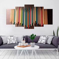 multicolored sticks hanging on the wall above a couch in a living room with white floors