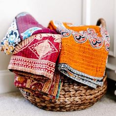 a basket filled with different colored cloths next to a door