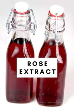 two glass bottles filled with red liquid and the words rose extract written in black ink