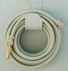 a white hose connected to an outlet with two gold connectors on the end and one plug in the middle