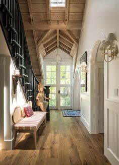 a hallway with wood flooring and white walls, along with an entry way leading to the front door