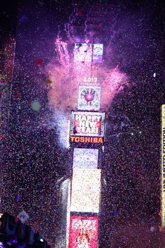 fireworks and confetti fill the night sky above times square