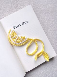 a crocheted brooch is laying on top of an open book with the words part one written in it