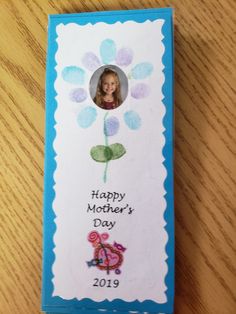 a mother's day card on a table with a photo in the center and flowers