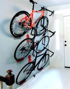 a bicycle mounted to the side of a wall with multiple bikes hanging from it's hooks