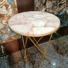 a marble topped table with gold legs on display in a store front window or restaurant