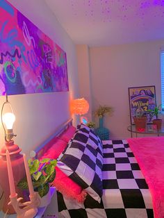 a bedroom with a checkered bed spread and colorful lights on the wall above it