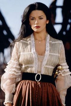 a woman wearing a white blouse and brown skirt