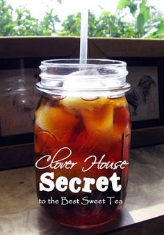 a mason jar filled with ice tea sitting on top of a table