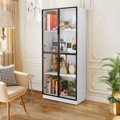 a white refrigerator freezer sitting inside of a living room next to a chair and table