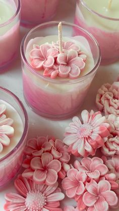 pink candles with flowers in them on a table