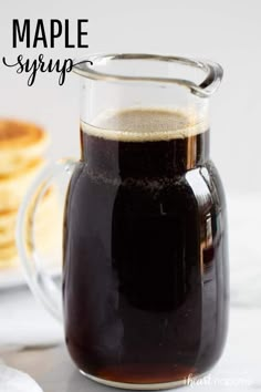 a glass pitcher filled with liquid next to pancakes