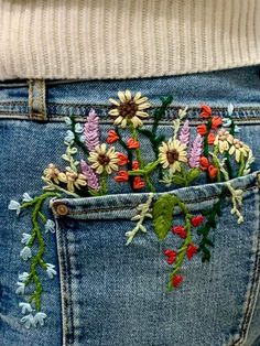 the back pocket of someone's jeans with flowers in it