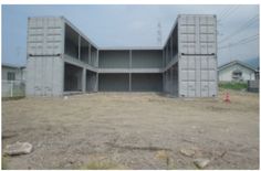 an empty lot with several storage containers in the middle and two buildings on each side