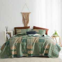 a bed covered in green and brown bedspread