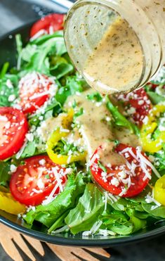 a salad with dressing being drizzled over it