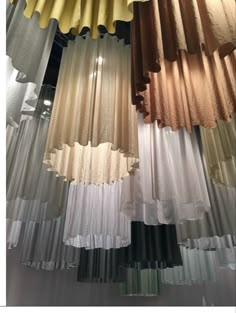 several different colored curtains hanging from the ceiling