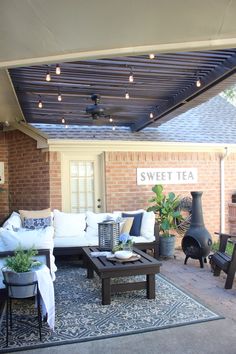 an outdoor living area with white furniture and potted plants