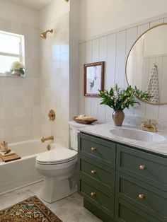 a bathroom with green cabinets and white walls